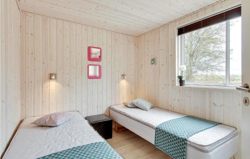 博恩瑟斯特兰巴肯博根斯四号度假屋的一间卧室设有两张床和窗户。