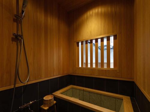 出云市Nipponia Izumo Hirata Cotton Road的带浴缸的浴室和窗户