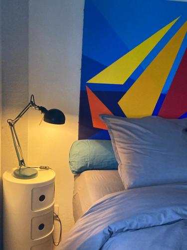 米卢斯King size lounge 76m2 de confort au centre ville的一间卧室,配有一张床和床头灯