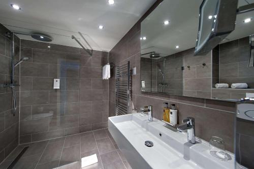 斯图加特斯图加特机场展览中心温德姆酒店的带浴缸、水槽和镜子的浴室