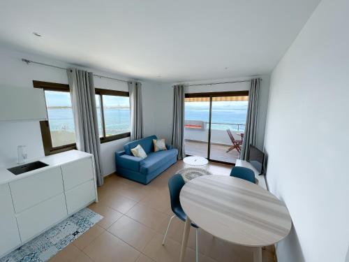 拉萨维纳Turquesa & Ambar Apartments Formentera的客厅配有桌子和蓝色沙发
