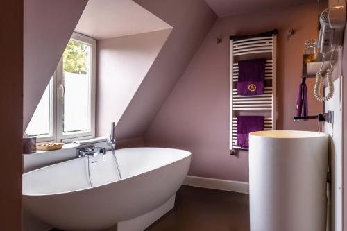 布鲁日Saint Georges Bruges Luxury Suites的一间带大型白色浴缸和窗户的浴室