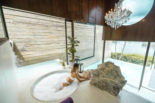 北碧Fallingwater Pool Villa by Cross River Kwai的坐在浴室浴缸里的女人