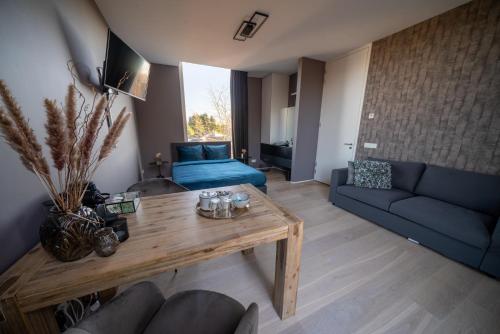 博克斯特尔Bed & Wellness Boxtel, luxe kamer met airco en eigen badkamer的客厅配有蓝色的沙发和桌子