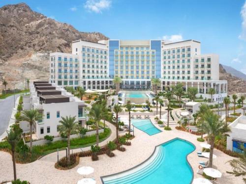 SharmOcean View Address Beach Resort Fujairah فندق و منتجع شاطئ العنوان الفجيره的享有带游泳池的度假村的空中景致