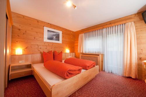 施图拜河谷新施蒂夫特Pension Kristall的一间卧室配有带橙色枕头的床