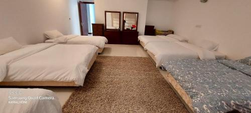 Durrat Al BahrainFamily friendly house in Bahrian的一间设有四张床的客房,位于带镜子的房间内