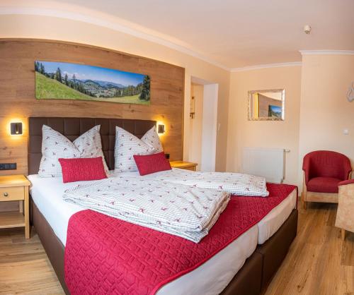 涅德劳Hotel Schneeberger的一间卧室配有一张带红色枕头的大床