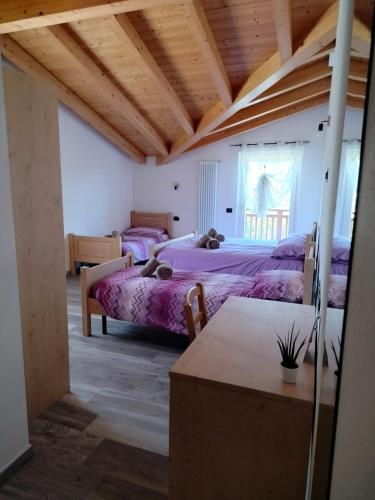 Nave San RoccoAgritur Lavanda的一间卧室设有两张床和木制天花板