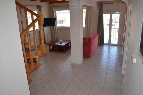 扎金索斯镇阿纳斯塔西娅公寓的一间带红色沙发和楼梯的客厅