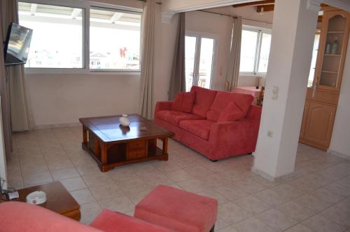 扎金索斯镇阿纳斯塔西娅公寓的客厅配有2张红色沙发和1张咖啡桌