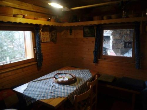 耶塞尼采A Cottage in the Alps for hiking, cycling, skiing的小屋内带桌子的房间,设有2个窗户