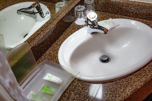 哈拉雷假日酒店 - 哈拉雷的浴室柜台设有水槽和白色水槽。
