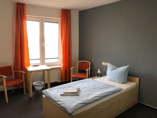 施韦特StroamCamp Schwedt - a84452的一间卧室配有一张床、两把椅子和一个窗户