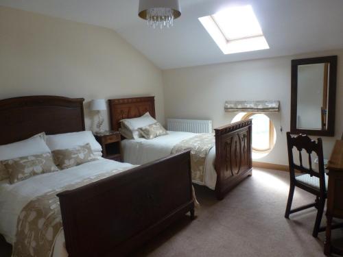 南特威奇Mile House Barn Bed & Breakfast的一间卧室设有两张床、镜子和窗户