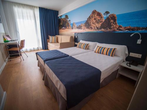 滨海托萨唐璜托萨酒店的卧室配有一张大床,墙上挂有绘画作品