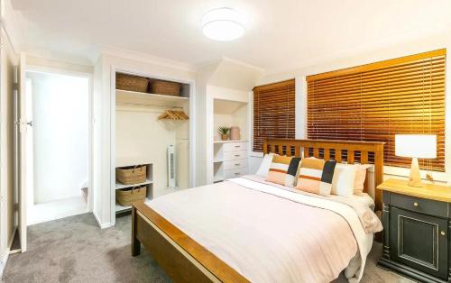 尼尔森湾Entire Nelson Bay home walk to the Beach and Town Centre的一间卧室设有一张大床和一个窗户。