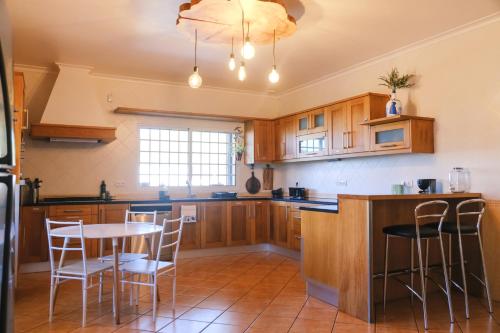 大里贝拉LAVA Açores Coliving & Coworking的厨房配有木制橱柜和桌椅
