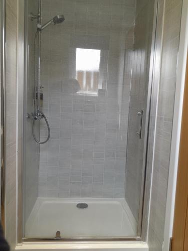 格伦科Glencoe view lodge的设有带白色浴缸的淋浴的浴室