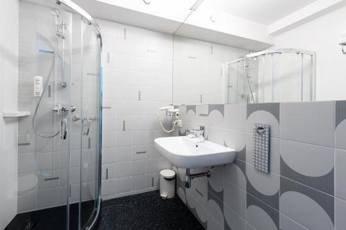 格但斯克住这儿酒店的白色的浴室设有水槽和淋浴。