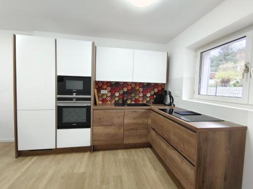 卡普芬贝格City House - up to 8 Persons的厨房配有白色橱柜和窗户。