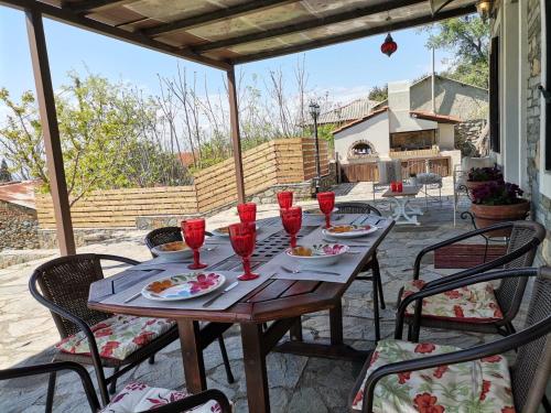 马罗尼亚Maronia Luxury Villa的庭院里配有一张带红葡萄酒杯的木桌