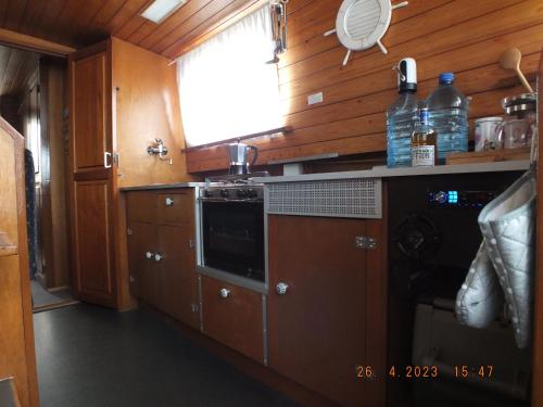 拉贝河畔罗乌德尼采Zouw Hausboat Zakotven -pouze ubytovaní的厨房配有木制橱柜和炉灶烤箱。