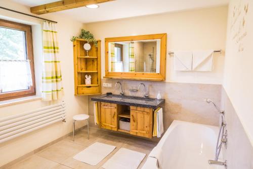 鲁波尔丁Ferienhaus Eva的带浴缸、水槽和镜子的浴室