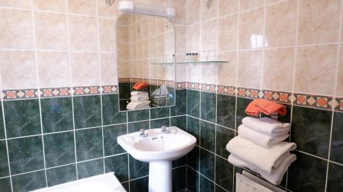 基尔罗南基尔默韦旅馆的绿色瓷砖浴室设有水槽和镜子