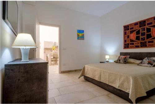 韦列Giardini Saraceni的一间卧室配有一张床和一张桌子上的台灯