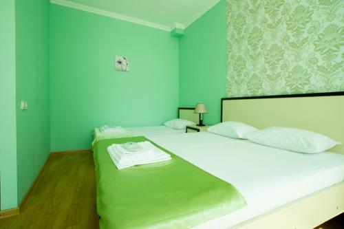 茨卡尔图博Chill Out Hotel的一间卧室设有两张带绿色墙壁的床