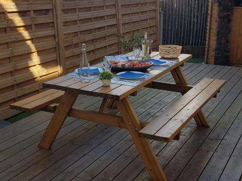 阿卡雄3 pièces avec terrasse arborée的甲板上带一碗食物的野餐桌