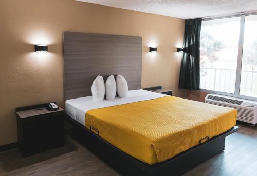 帕勒斯坦Express Inn & Suites的一间设有大床和窗户的酒店客房