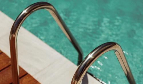 帕福斯Regency Boutique Hotel Holiday Suites的游泳池旁的金属栏杆
