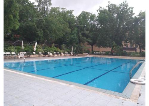 朱巴Juba Landmark Hotel的一个带椅子和树木的大型蓝色游泳池