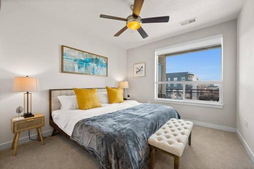 盐湖城Downtown Walking Oasis with King BD and City View的一间卧室配有一张带吊扇和窗户的床。
