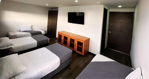 波哥大Hotel Expo Hotel Ferial的酒店客房设有两张床和一台平面电视。