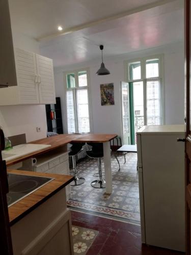 普拉德莫洛拉普雷斯特Studio tout confort dans le centre historique的厨房配有白色橱柜和木桌