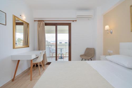新马尔马拉斯Star Paradise Hotel的一间卧室配有一张床、一张书桌和一个窗户。