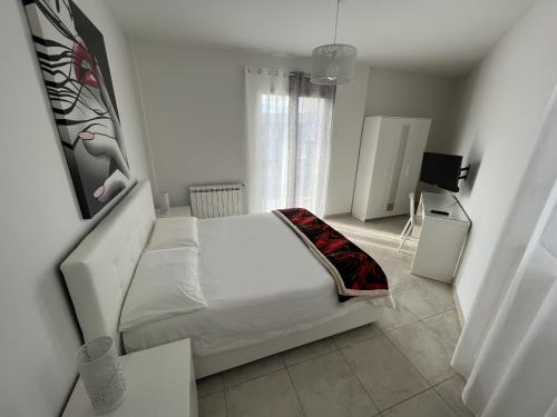 帕泰尔诺Casa Vacanze Le Tre Scimmiette的白色的卧室设有床和窗户
