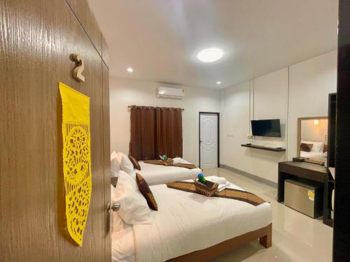 清莱บ้านกาญจน์ เชียงราย Baan Kan Chiang Rai的酒店客房设有两张床和电视。