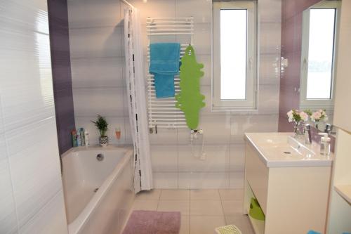 韦伦采Panorama Apartman的白色的浴室设有浴缸和水槽。