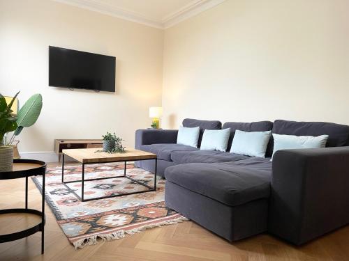 巴尔内特Glenlyn Hotel & Apartments的客厅配有蓝色的沙发和电视