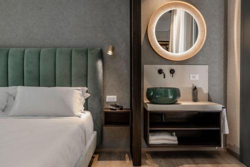 里乔内Hotel Sole的一间卧室配有床、水槽和镜子