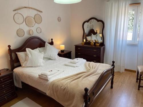 索布拉尔德蒙特阿格拉苏Quinta do Carvalheiro的卧室配有一张带白色床单的大床和梳妆台。