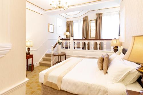 南安普敦Botleigh Grange Hotel - Pool & Spa under renovation的卧室设有白色大床和楼梯。