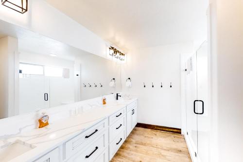 加登城Bear's Eye View的白色的浴室设有两个盥洗盆和大镜子