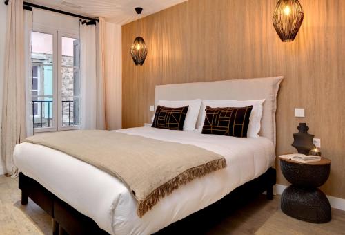 科利尤尔Les Appartements de Collioure的卧室设有一张白色大床和一扇窗户。