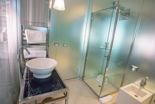 圣马力诺Hotel iDesign的一间带玻璃淋浴和水槽的浴室