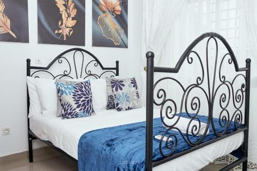 杜阿拉L'IMMEUBLE QUEEN M.N.M的一张黑色和白色的床,配有蓝色的床单和枕头